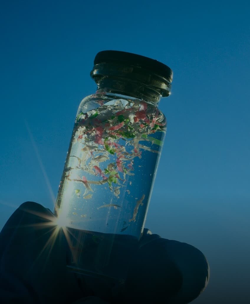 Plastic bag floating underwater near a coral reef, illustrating ocean plastic pollution.