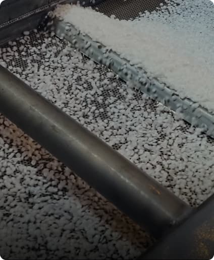 Plastic pieces moving through industrial machinery, driving petition for recycling reform.