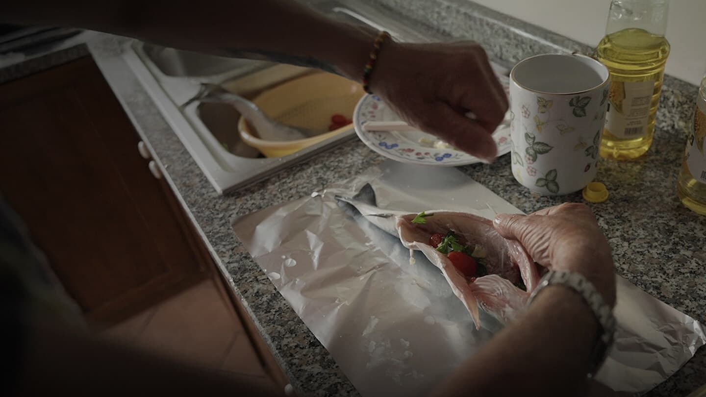 Hands preparing a fish, showing the study of microplastics and plastic pollution in Italy.