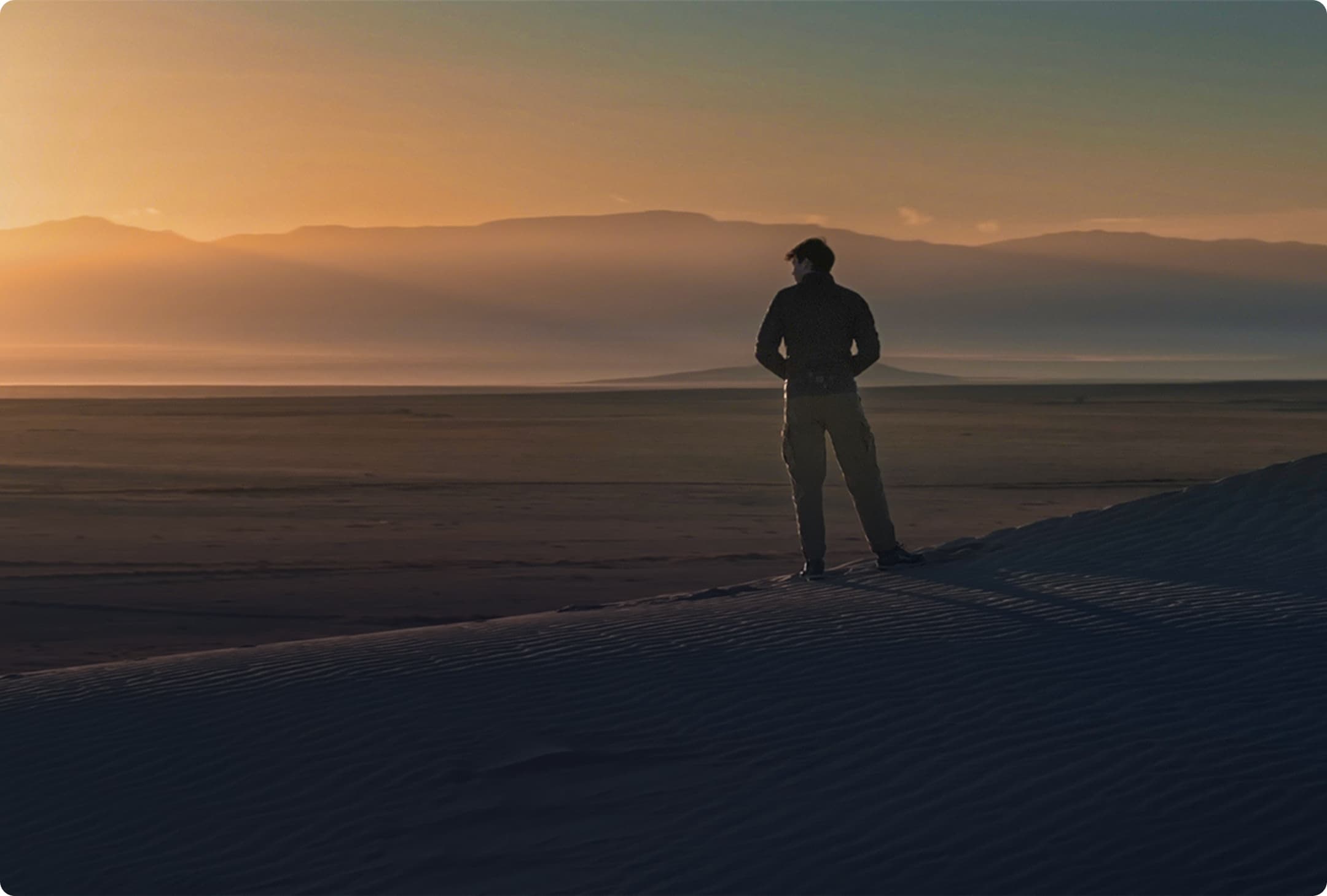 Scientist in New Mexico desert as sun rises over mountains contemplates microplastic discoveries