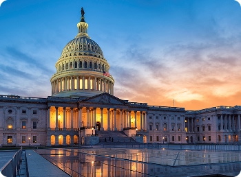 Capitol building at dusk with lights on, urging action on the growing plastic waste crisis.